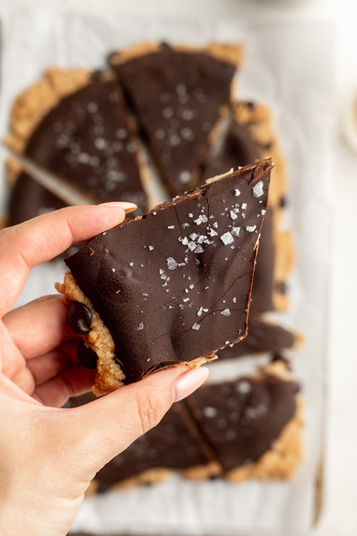 Protein Cookie Dough Bark a piece of protein cookie dough bark with flaky salt on top.