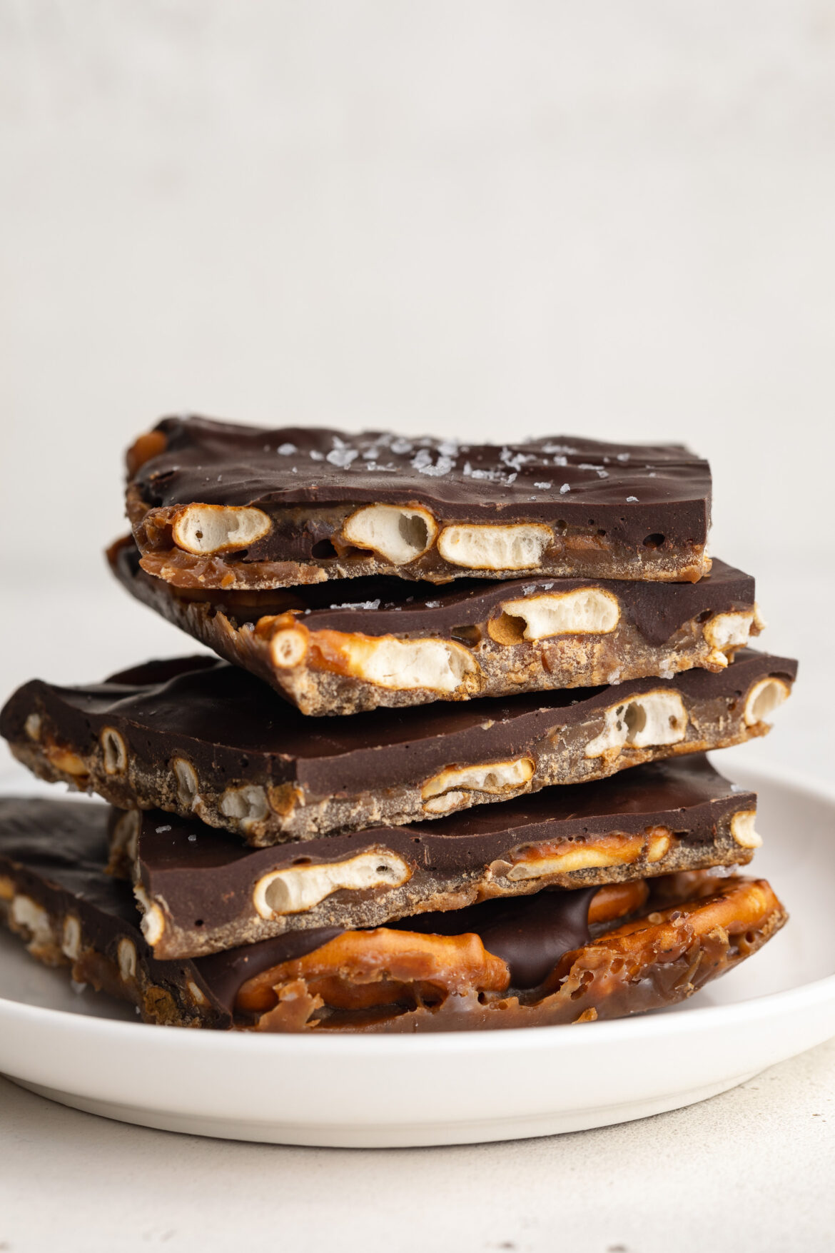 4-Ingredient Chocolate Toffee Pretzel Bark (gluten-free & dairy-free!) a stack of chocolate toffee pretzel bark on a plate.