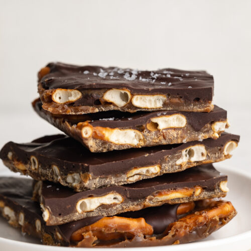 a stack of chocolate toffee pretzel bark on a plate.