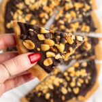Hand holding a piece of 4 ingredient peanut butter cup cookie dough bark.