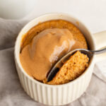 3 ingredient peanut butter mug cake with extra peanut butter on top.