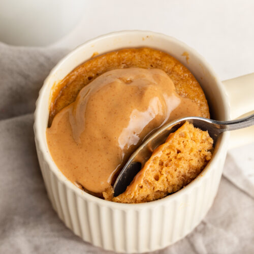 3 ingredient peanut butter mug cake with extra peanut butter on top.
