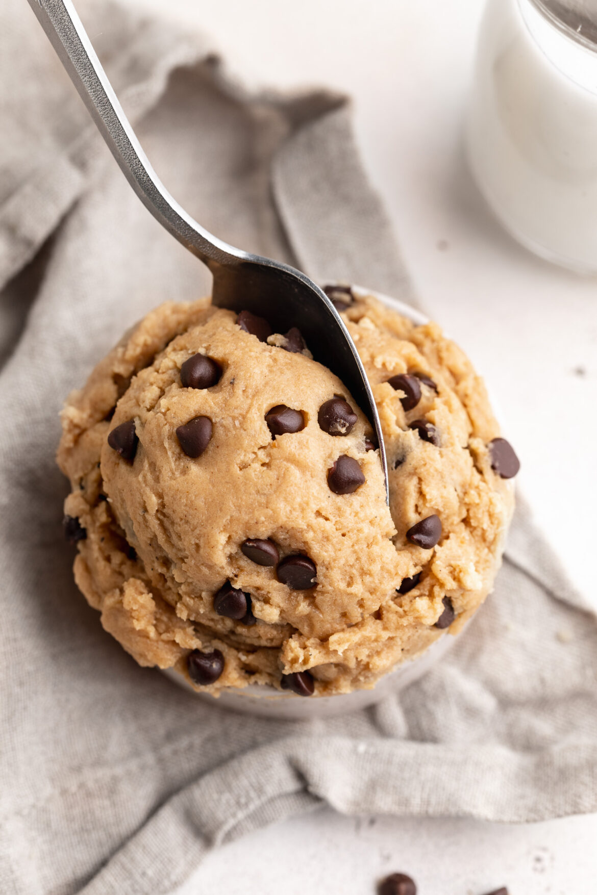 5-Ingredient Edible Protein Cookie Dough Recipe 5 ingredient edible protein chocolate chip cookie dough in a small cup with a spoon.