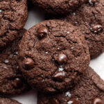 almond flour chocolate cookies on top of each other of a baking sheet.