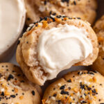 Close up image of a gluten-free bagel bite with everything bagel seasoning and cream cheese.
