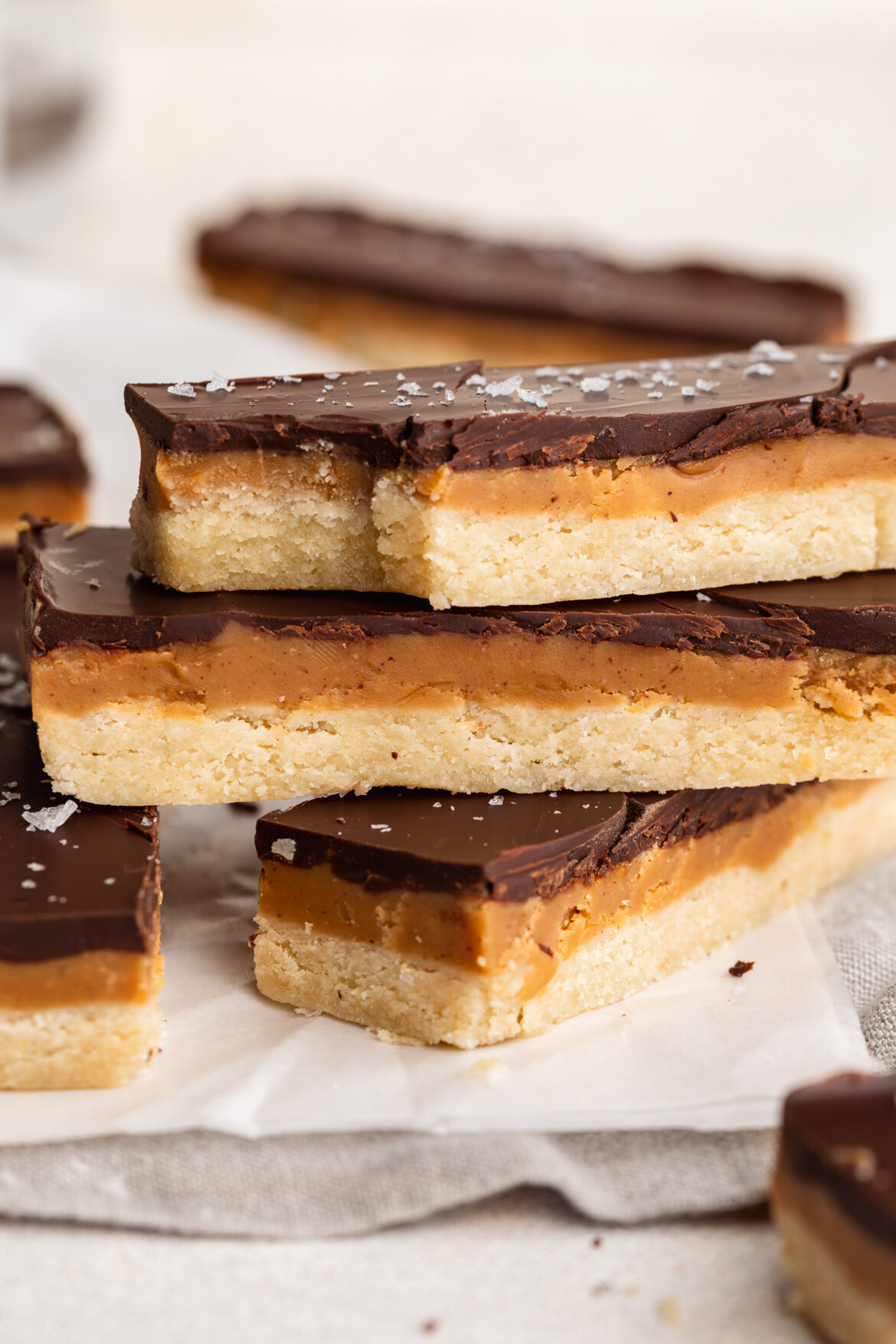 6-Ingredient Healthy Twix Bars (gluten-free & vegan!) healthy twix bars stacked on top of each other with flaky salt on top.