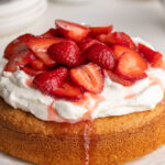 gluten-free strawberry shortcake on a table with whipped cream and fresh strawberries on top.