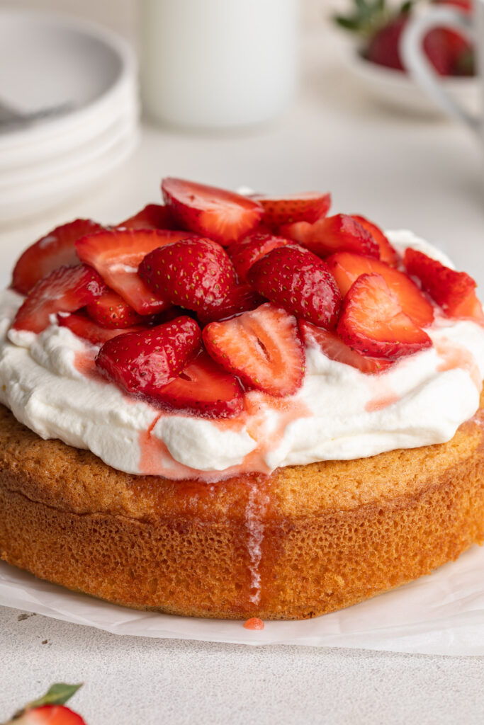 gluten-free strawberry shortcake on a table with whipped cream and fresh strawberries on top.