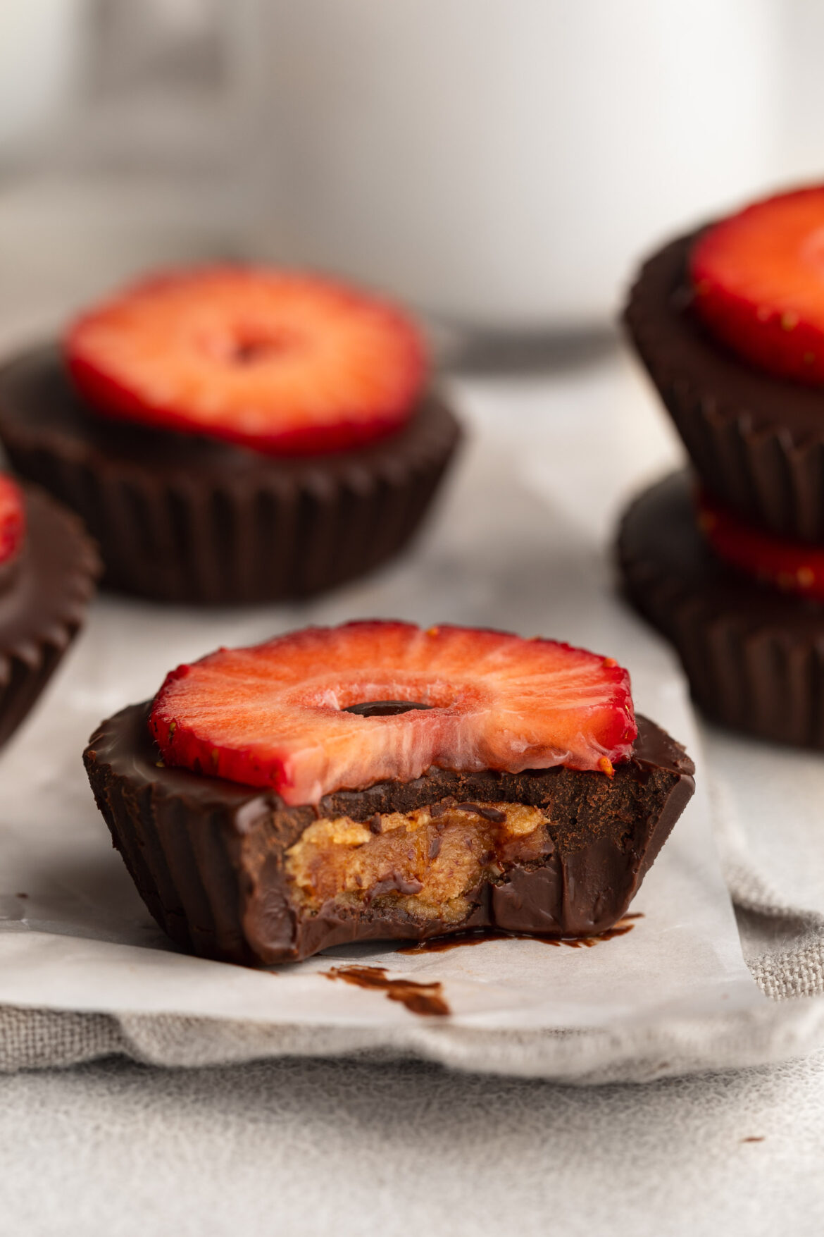 Healthy Strawberry Peanut Butter Cups a healthy strawberry peanut butter cup with a bite taken out.
