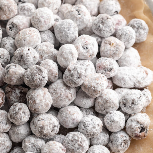 blueberry muddy buddies on a plate with chocolate chips on the side.