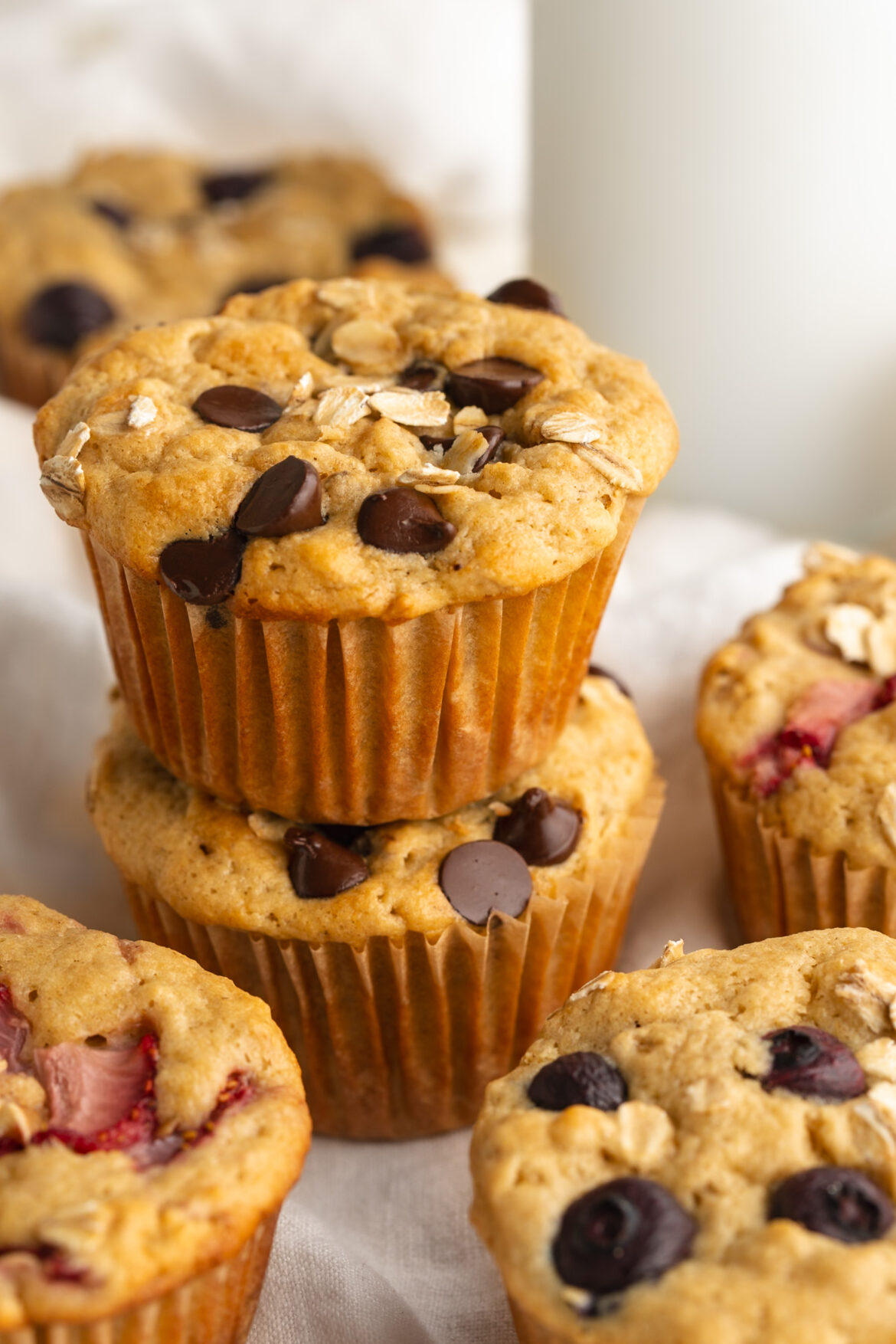 Healthy Oat Breakfast Muffins (3 ways!) two healthy breakfast muffins with chocolate chips stacked on top of each other.