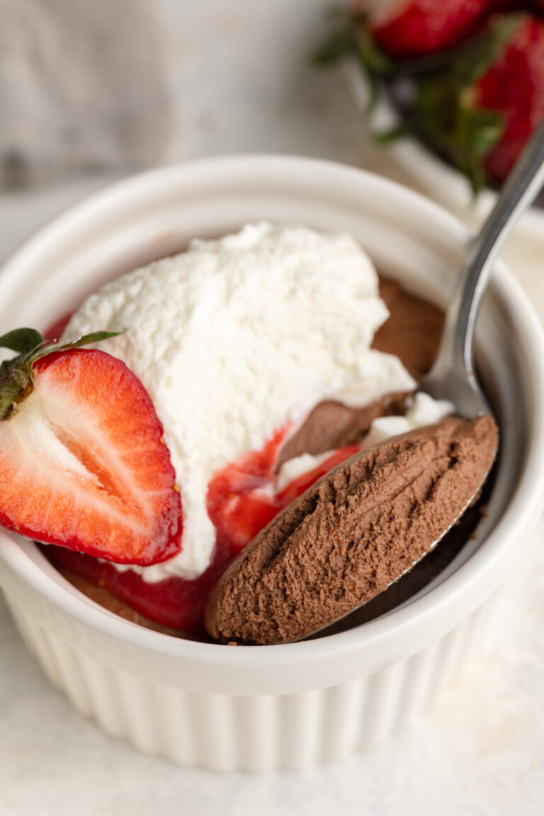 close up image of 3 ingredient healthy chocolate mousse in a ramekin with a spoon.