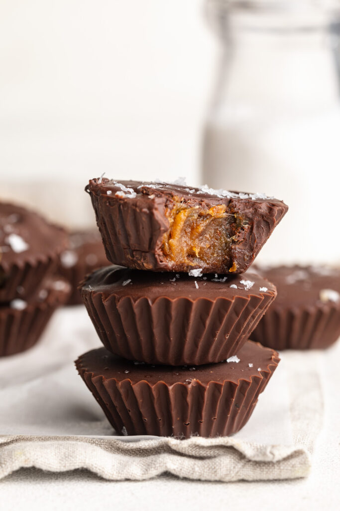 3 healthy date caramel cups stacked on top of each other.