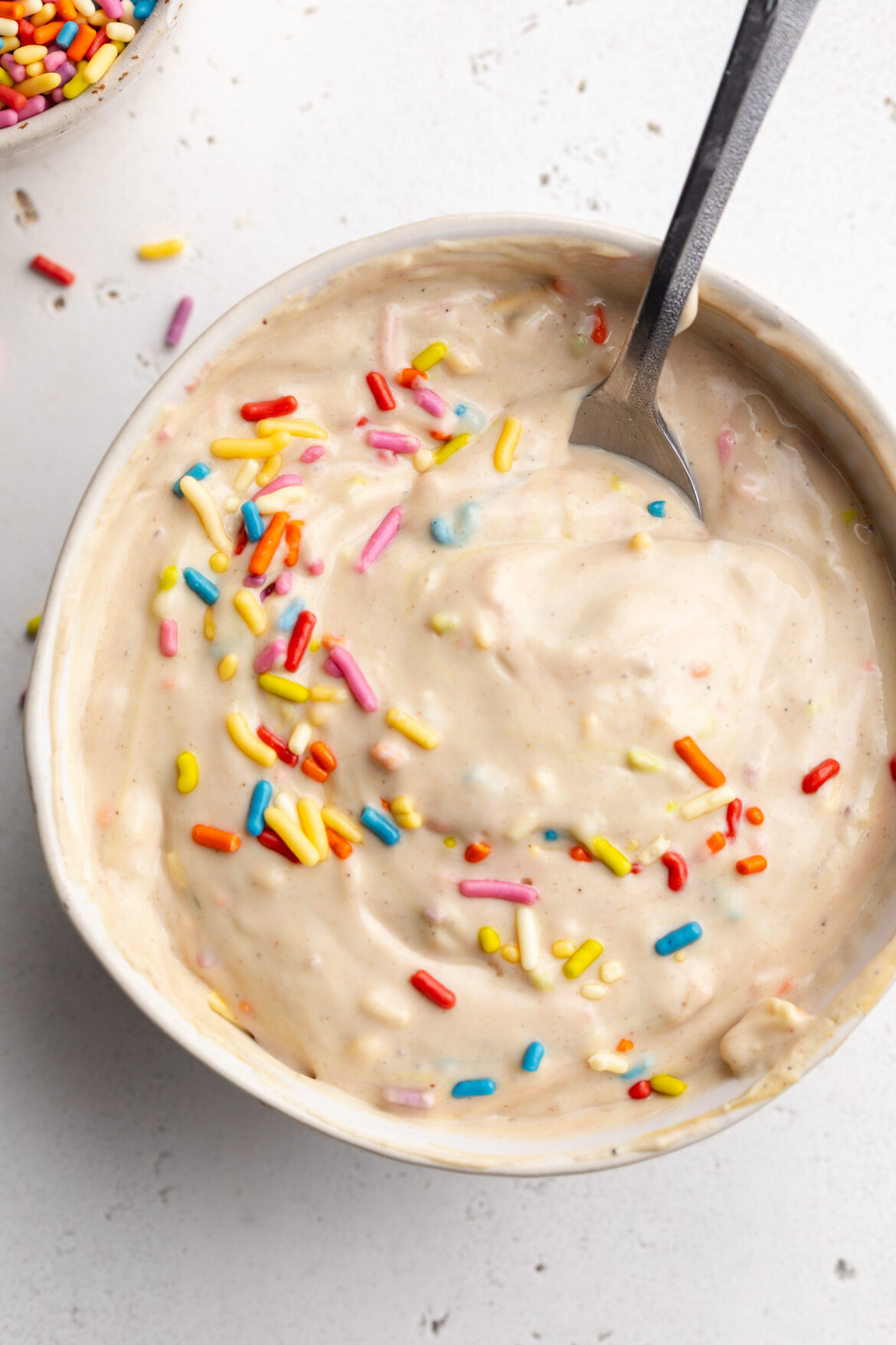 4-Ingredient Protein Dunkaroo Dip (20g protein!) overhead image of 4 ingredient protein dunkaroo dip in a small bowl with rainbow sprinkles on top.