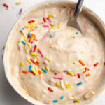 overhead image of 4 ingredient protein dunkaroo dip in a small bowl with rainbow sprinkles on top.