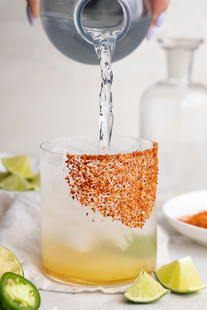club soda being poured into a spicy margarita mocktail glass.