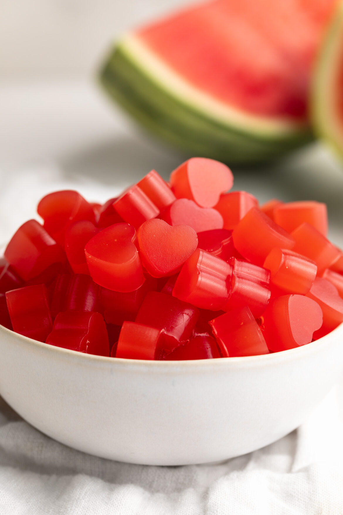 3-Ingredient Healthy Watermelon Gummies small bowl of 3 ingredient healthy watermelon gummies with fresh watermelon on the side.