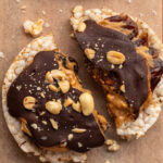 a healthy snicker rice cake broken in half.