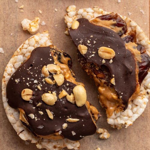 a healthy snicker rice cake broken in half.