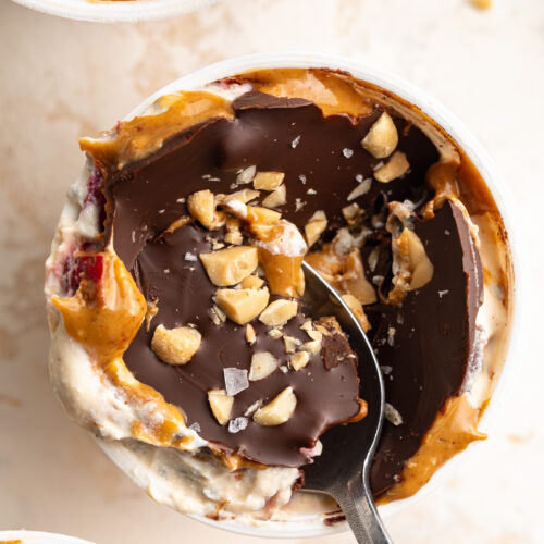 overhead image of chocolate shell yogurt cup with chopped peanuts on top.