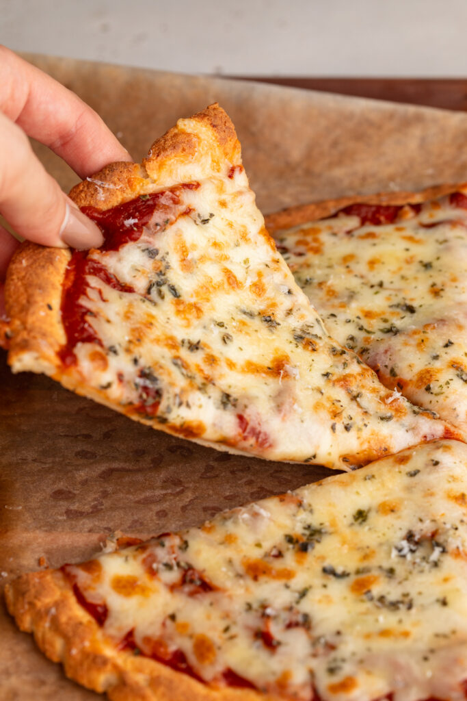 a slice of cottage cheese pizza crust being lifted up.