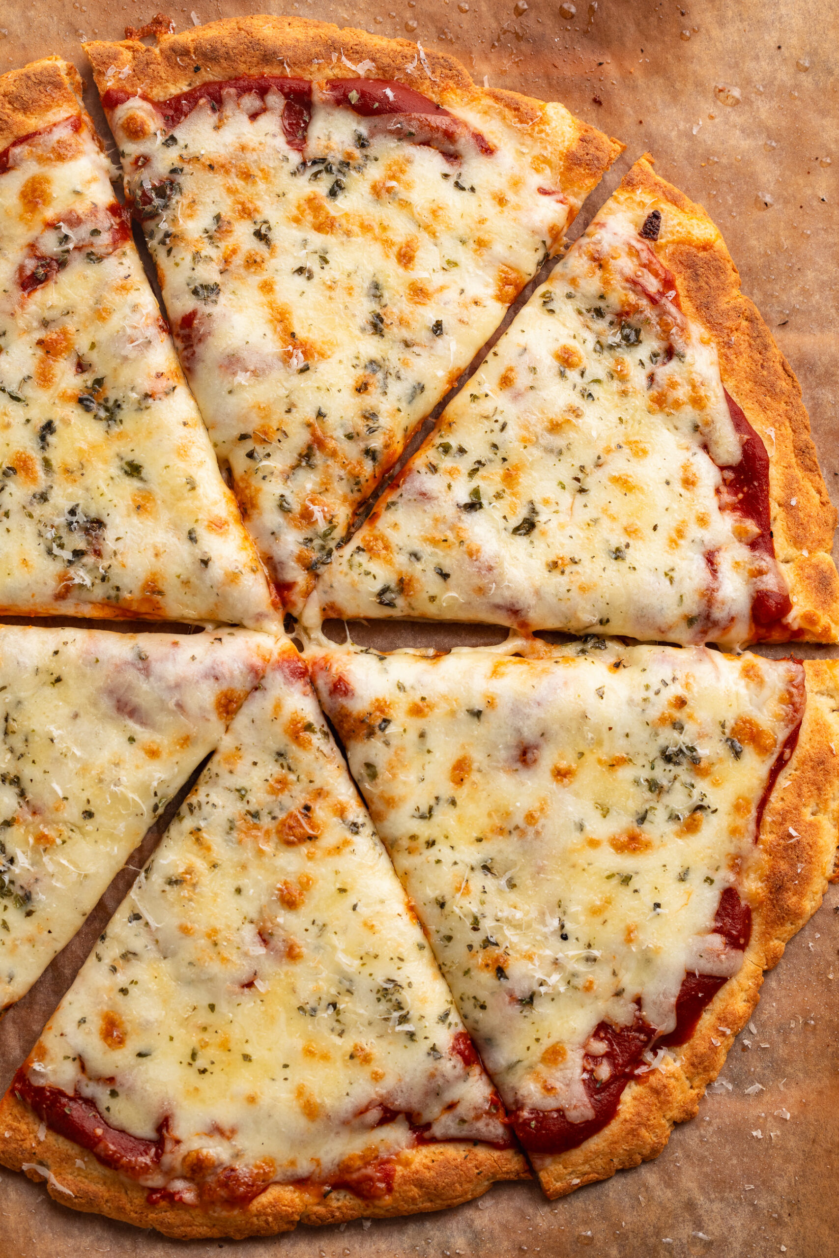 overhead image of cottage cheese pizza crust with sauce and cheese on top.