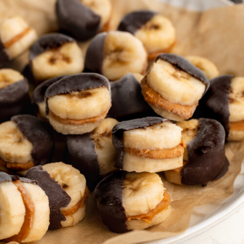 frozen banana and peanut butter bites dipped in chocolate on a plate