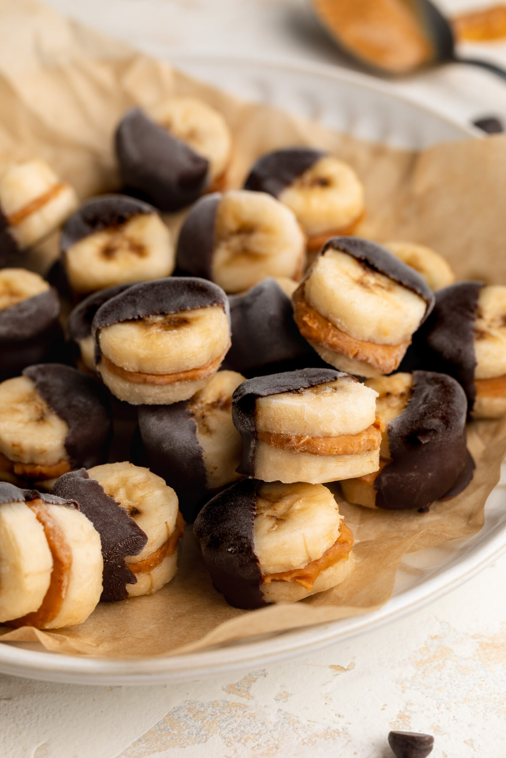 frozen banana and peanut butter bites dipped in chocolate on a plate
