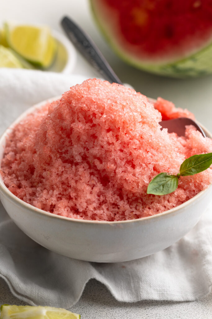watermelon shaved ice in a small bowl with a spoon.