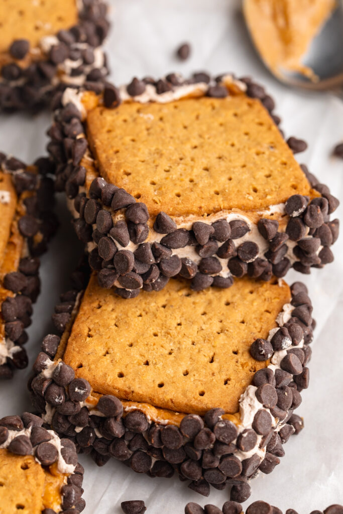 frozen chocolate protein peanut butter s'mores bars stacked on top of each other on a table.