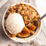 overhead image of single serve apple crumble with a scoop of ice cream on top.