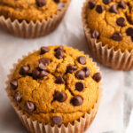 three healthy pumpkin muffins on parchment paper.