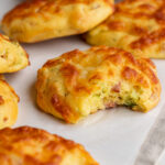 high protein breakfast biscuits on a table with a bite taken out.