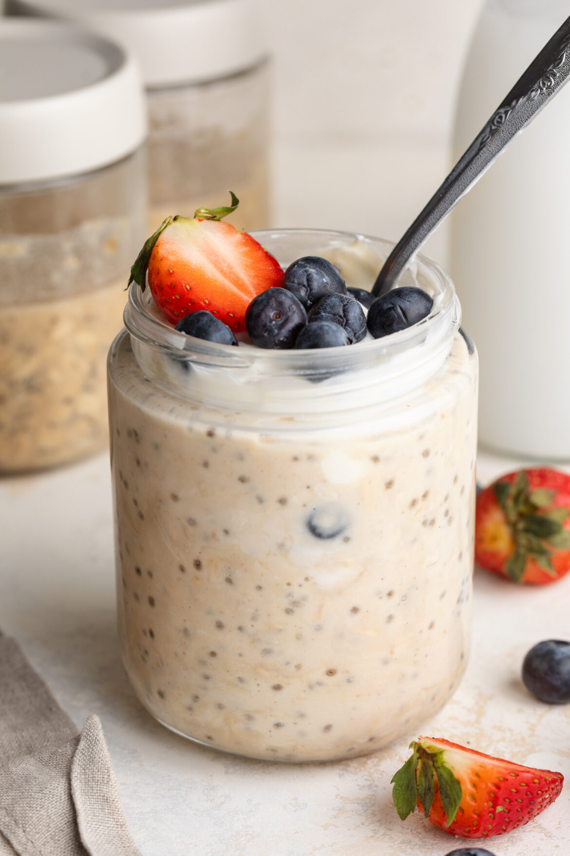 high protein overnight oats in a jar with fresh berries on top.