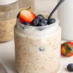 high protein overnight oats in a jar with fresh berries on top.
