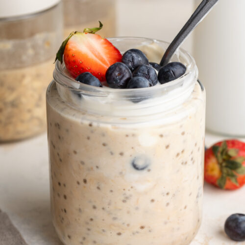 high protein overnight oats in a jar with fresh berries on top.