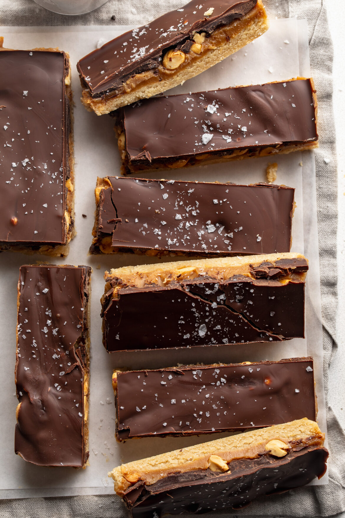overhead image of healthy snickers bars on a table with flaky salt on top.