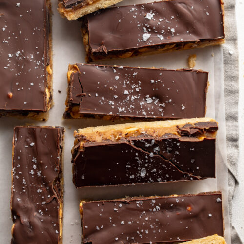 overhead image of healthy snickers bars on a table with flaky salt on top.