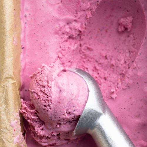 overhead image of cottage cheese ice cream being scooped with an ice cream scoop.