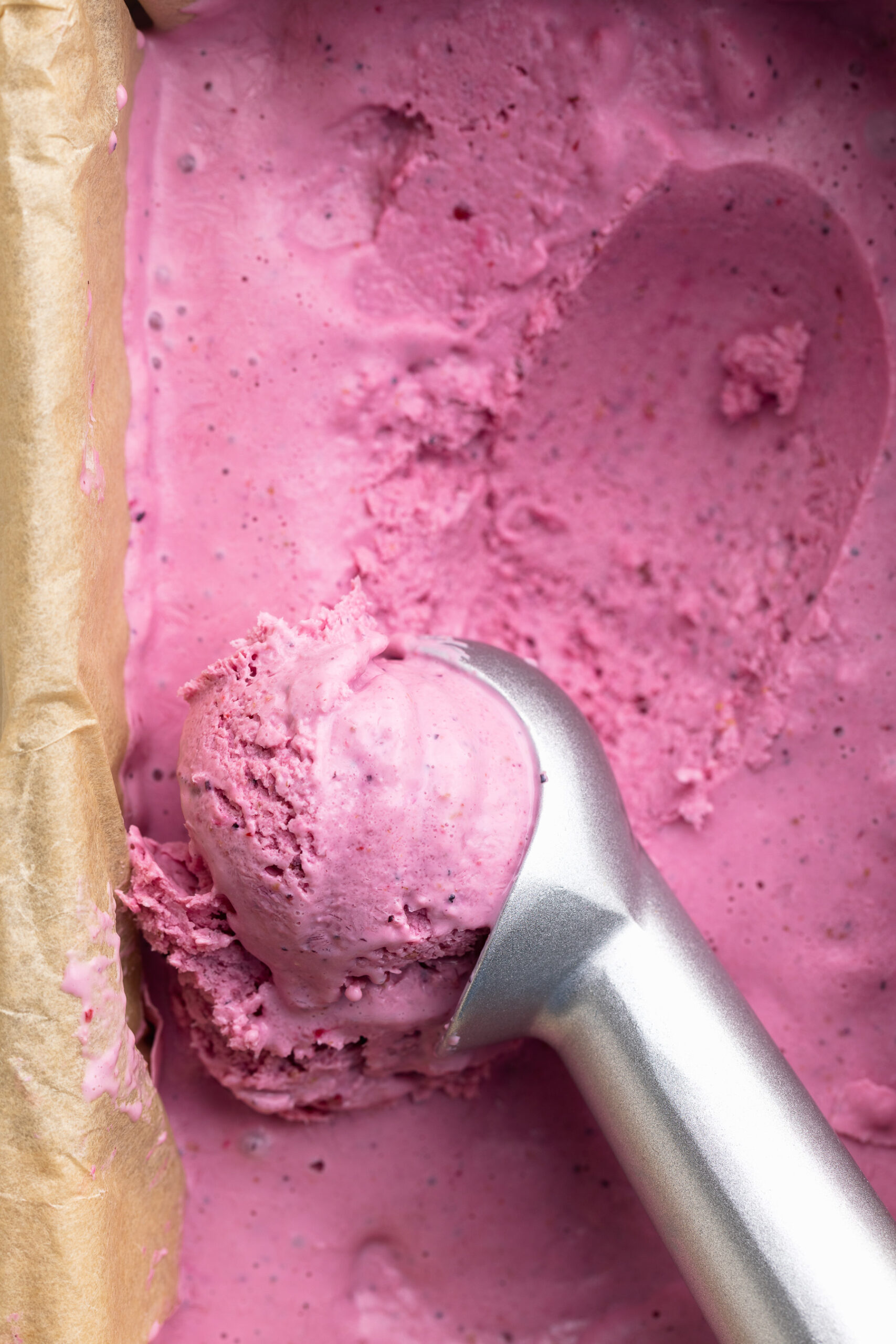 overhead image of cottage cheese ice cream being scooped with an ice cream scoop.