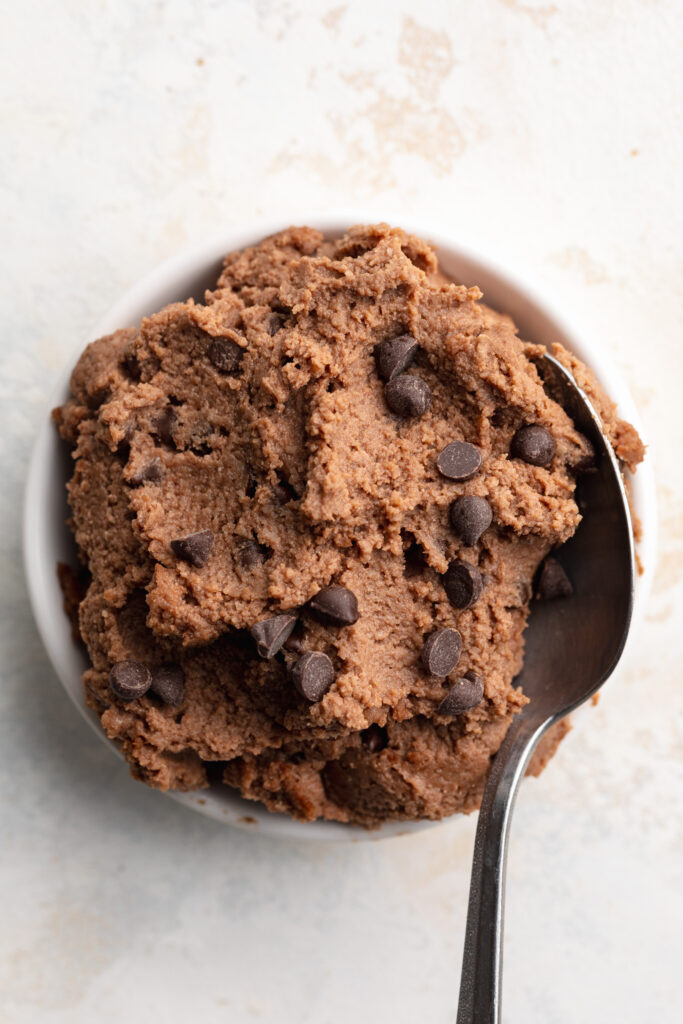 overhead image of cottage cheese brownie batter in a small dish with a spoon.