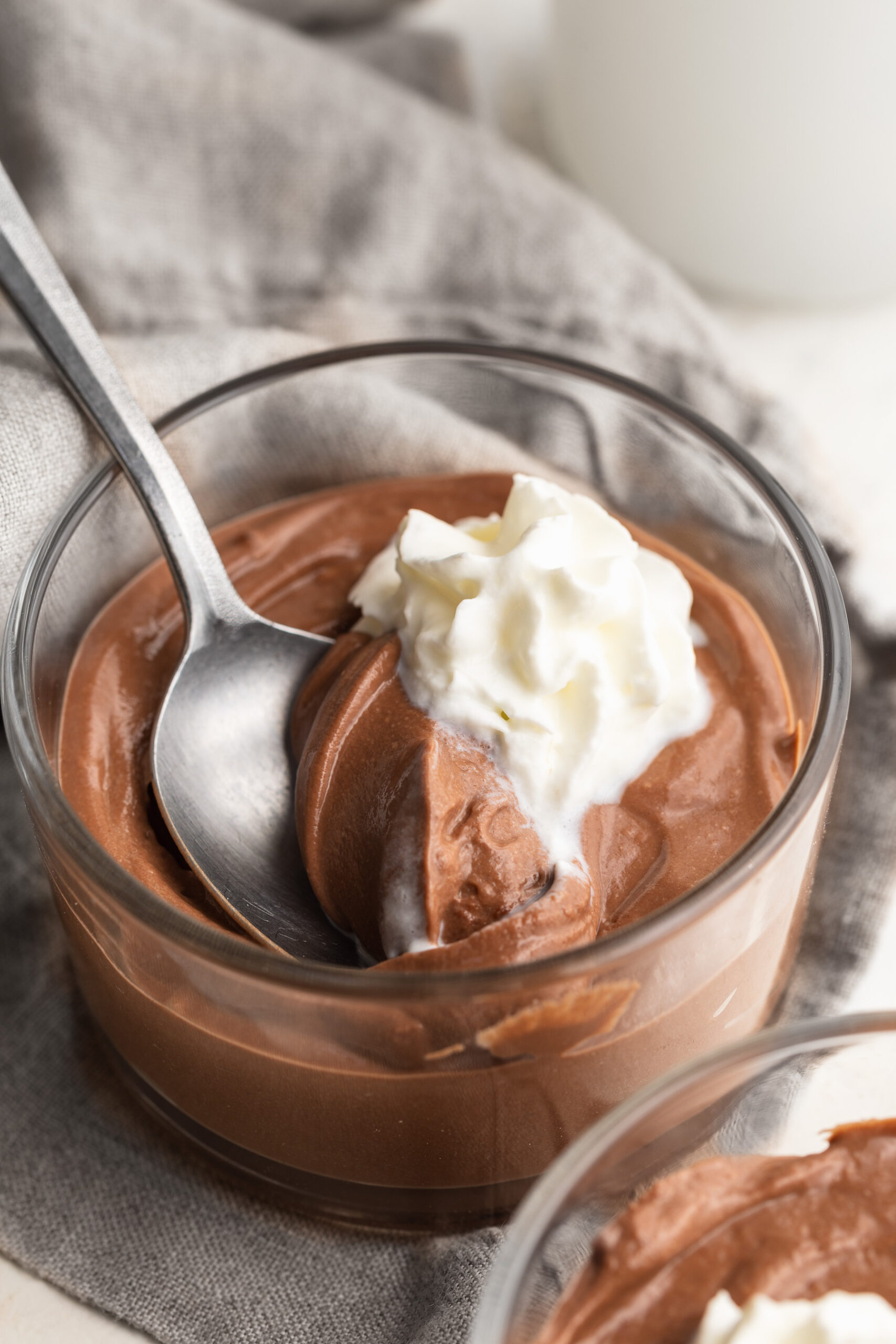 cottage cheese chocolate mousse in a small dish with whipped cream and a spoon.