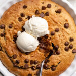 overhead image of healthy cookie pie in a pie dish with ice cream on top.