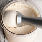 2 ingredient protein ice cream in a ninja creami cup with an ice cream scoop.