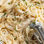 close up image of cottage cheese alfredo in a skillet with fresh parsley on top.