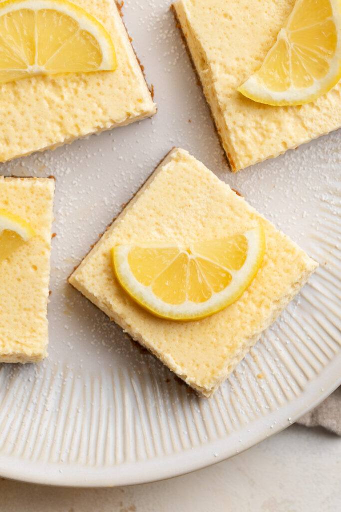 overhead image of a healthy cottage cheese lemon bar on a plate with a lemon slice on top.