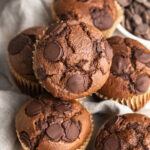 double chocolate protein muffins stacked on a table.