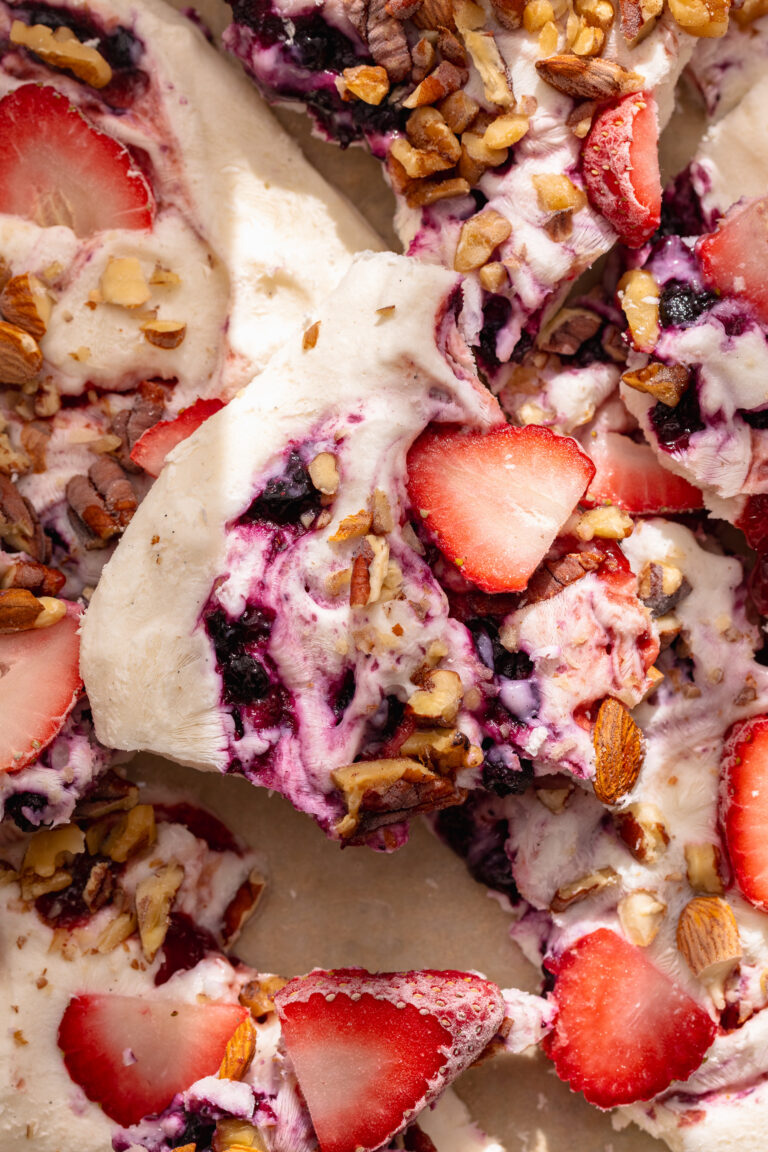 close up image a piece of frozen yogurt bark with fresh strawberries on top.