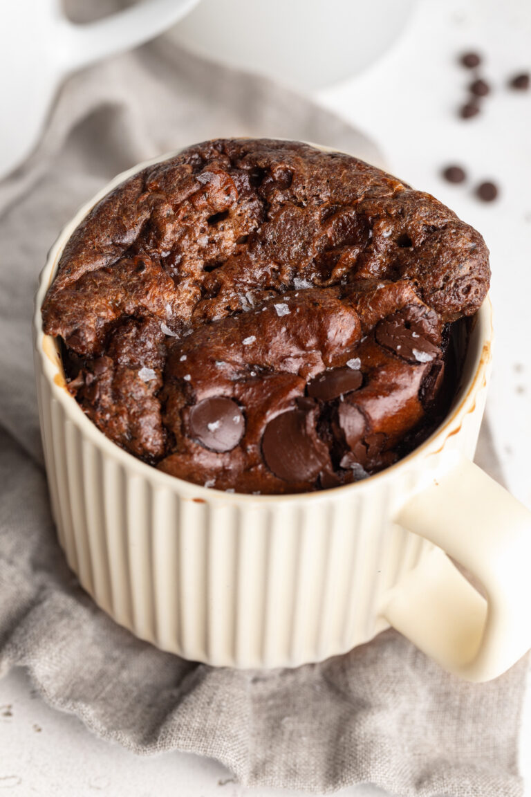 freshly baked protein brownie mug cake with chocolate chips and flaky salt on top.