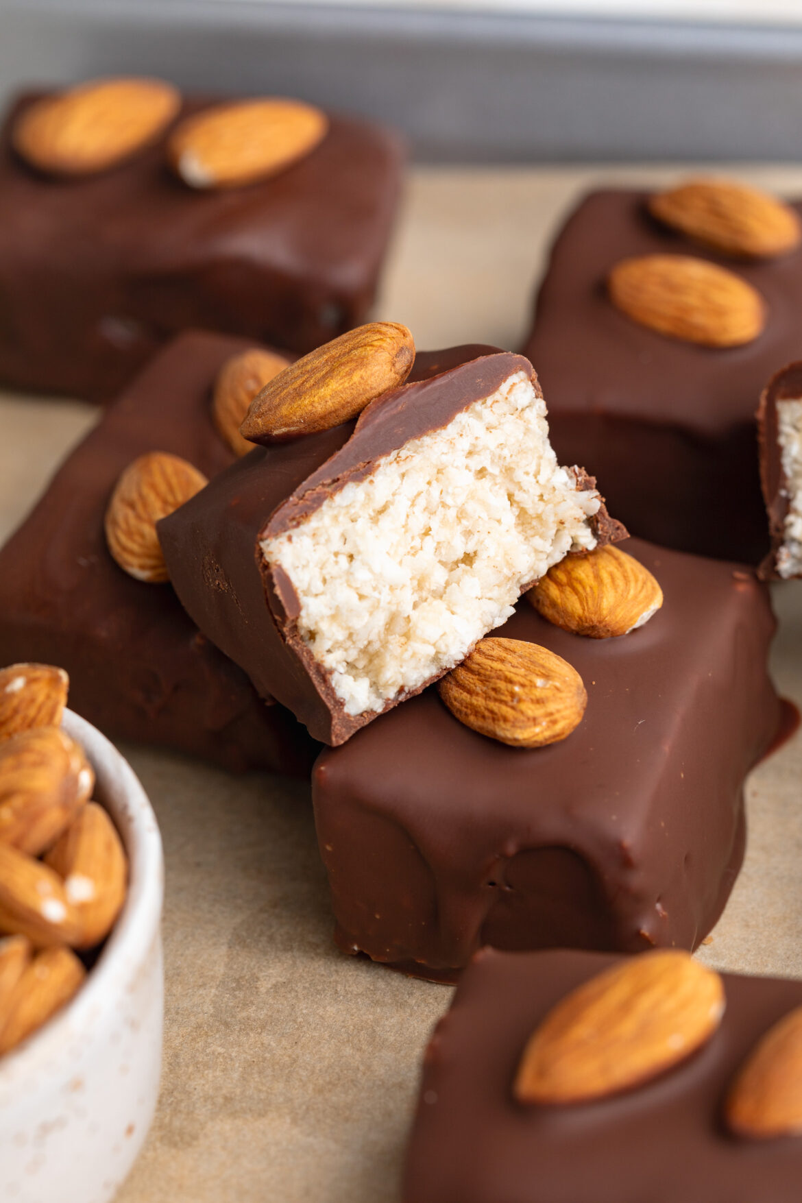 healthy almond joys bars, one cut in half to show the inside.